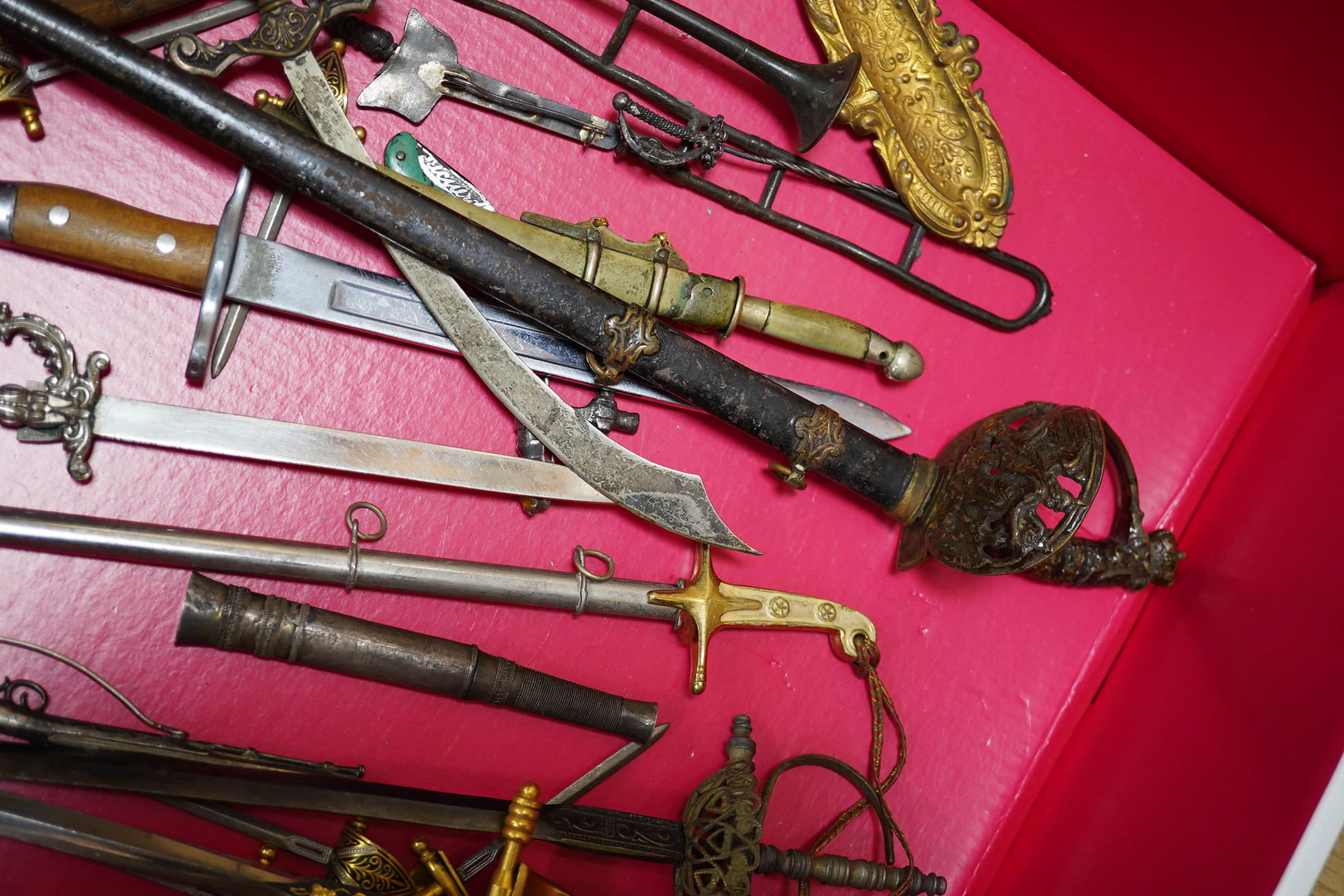 A large collection of miniature weapons, comprising approximately thirty-four edged weapons, and thirteen assorted firearms, approximately half contained within a mahogany case. Condition - fair to good